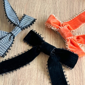 Détail de barrettes à nœuds en velours et à carreaux avec dentelle sur bois