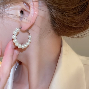 Close-up of elegant pearl hoop earrings on a model showing natural luster and style
