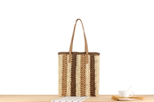 Detailed texture of colorful striped paper straw tote with brown leather handles