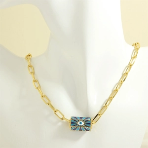 Detail of chunky gold chain necklace with blue and white enamel evil eye pendant charm