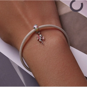 Close-up of model wearing S925 silver mesh bracelet with flower fairy enamel charms