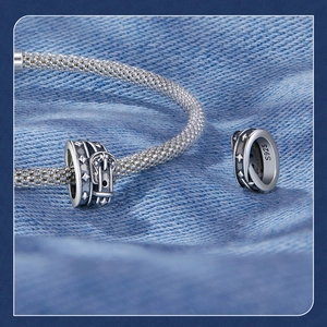 Macro shot of S925 sterling silver belt buckle charm on a mesh chain bracelet