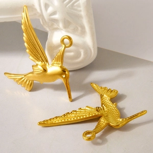 Two golden hummingbird pendants in stainless steel shown from front and back view