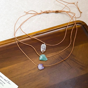Detailed macro view of natural tiger eye stone pendants with woven cords in three colors