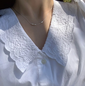 Detail of S925 sterling silver snake chain necklace with three oval bead pendants on model