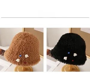 Detailed close-up of plush bucket hats in brown and black with colorful bead accents