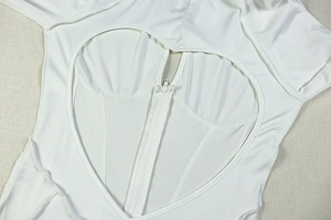 Detail of heart-shaped cutout with functional zipper on white knitted bodysuit