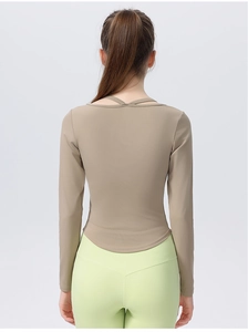 Close-up of slim-fit yoga top featuring stylish criss-cross back straps and curved hemline