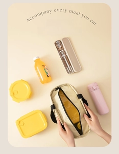 Flat lay of cream canvas lunch bag with yellow containers and pink thermos bottle