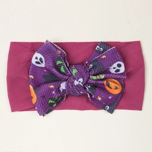 Dettaglio fascia Halloween per bambini con fiocco viola e motivi di zucche e fantasmi