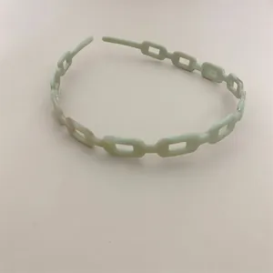 Close-up of mint green acetate headband with minimalist hollow chain link design