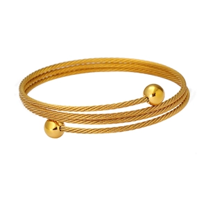 Dettaglio del bracciale a spirale a tre strati in oro con estremità sferiche in acciaio