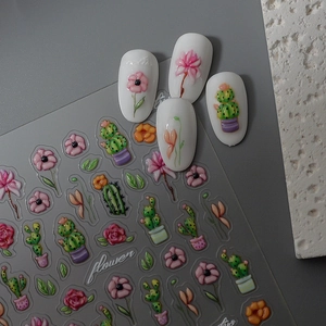 Detailed view of 5D embossed cactus and flower nail art stickers on white oval nails