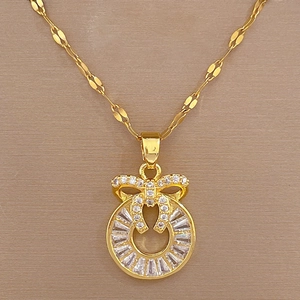 Macro view of gold bow pendant necklace featuring baguette cut and round cz diamonds