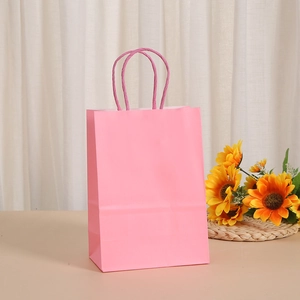 Pink eco-friendly kraft paper gift bag with matching paper twist handles and sunflower