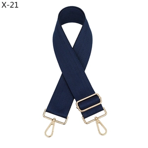 Dettaglio tracolla blu navy con trama a spina di pesce e fibbia in metallo dorato lucido