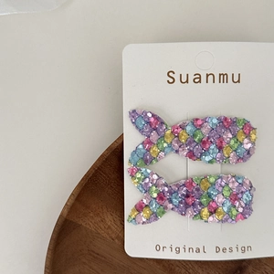 Macro detail of sparkly sequin mermaid scale hair clips for children on display card