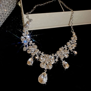 Macro shot of silver necklace featuring rhinestone floral patterns and teardrop pendants