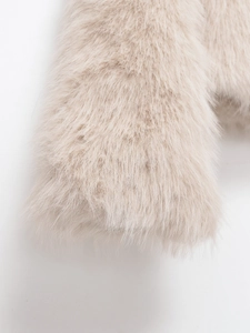 Vue détaillée de la texture en fausse fourrure beige doux sur la manche courte