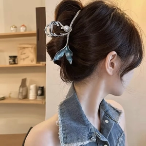 Elegant fishtail hair claw clip with blue gradient fin and pearl in a hair bun