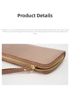Detalle de cartera larga rosa con textura de cocodrilo, cremallera dorada y correa