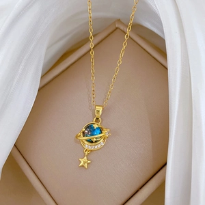 Detailed close-up of a golden planet pendant with blue starry core and a dangling star