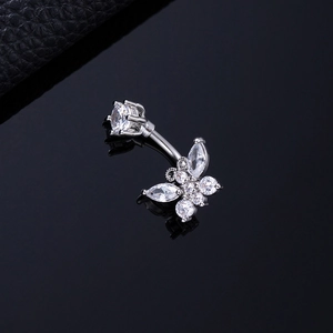 Detailed macro view of a silver butterfly belly ring with sparkling zircon stones