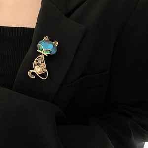 Detailed view of fox brooch with blue gemstone head and crystals on black blazer lapel