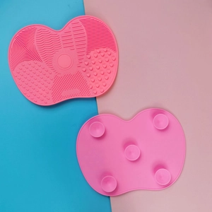 Detail of pink silicone makeup brush cleaning mat showing textured surface and suction cups