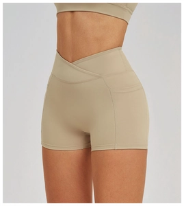 Detail view of khaki cross-waist yoga shorts showing high-rise design and side pockets