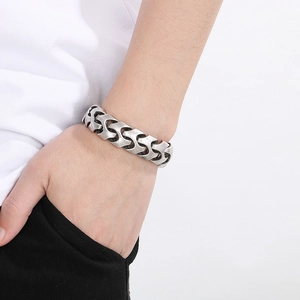 Close-up of men's silver punk dragon bone chain bracelet with interlocking metal texture