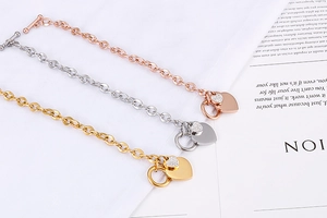 Detailed view of heart charms on gold, silver, and rose gold OT buckle chain bracelets