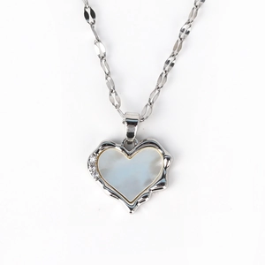 Detailed macro of vintage silver heart necklace with white shell inlay and zircon stones