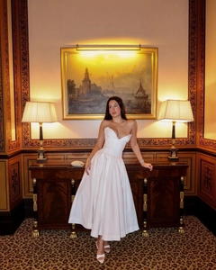 Detail of white strapless evening dress with corset waist and deep V-neckline cut