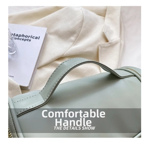 Close-up detail of the portable cosmetic bag handle, elegant green leather finish texture design.