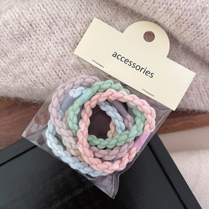 Detail of colorful braided elastic hair ties in pastel tones with card packaging