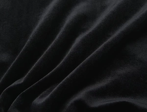 Macro detail of premium black velvet fabric showing soft texture and elegant sheen