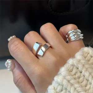 Detail of S925 silver layered stackable rings and irregular wide band on model hand