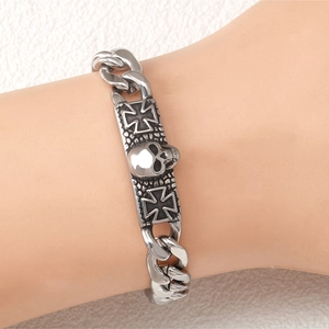 Silver stainless steel cuban link bracelet with skull and iron cross charms on wrist