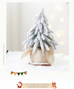 Macro shot of flocked Christmas tree branches with fake snow and rustic burlap base