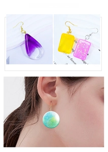 DIY resin earrings in colorful geometric shapes with glitter and metal hooks on a model