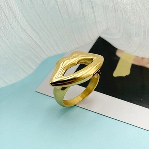 Detailed side view of a polished 18K gold lip-shaped ring on white fabric