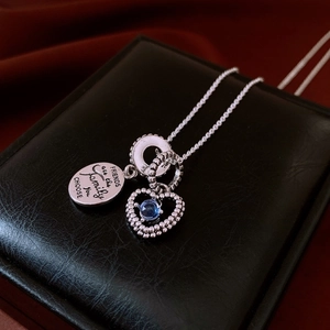 Dettaglio della collana cuore in argento con pietra blu e incisione amicizia su scatola