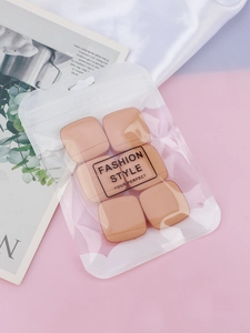 Detail of 6 skin-tone square breast tape pieces in fashion style zip packaging