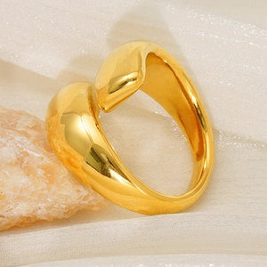 Polished minimalist gold wrap-around open ring set on neutral stone and soft fabric