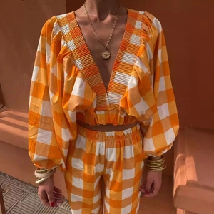 Orange gingham two-piece set with V-neck puff sleeve top and matching high waist pants
