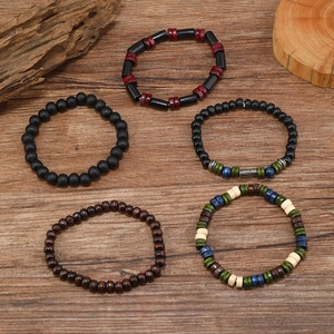 Detailed flat lay of men's multi-layered beaded bracelets on rustic wood background