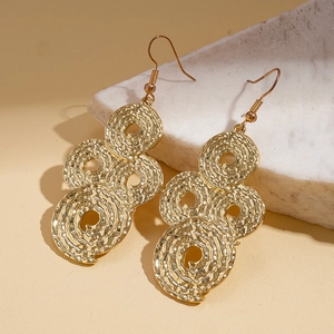 Detail of gold drop earrings with hammered texture and triple circle link design