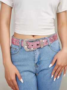 Macro detail of pink glitter belt with rhinestone buckle and metal eyelets in Y2K style