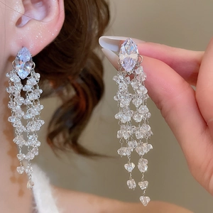 Detail shot of long silver tassel earrings with clear marquise crystal stones on model